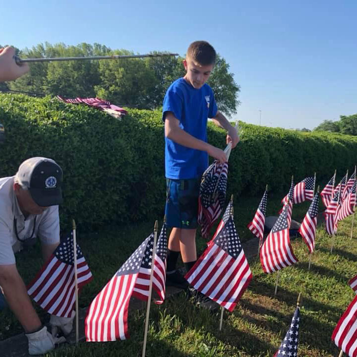 Little boy helping place miniature American flags