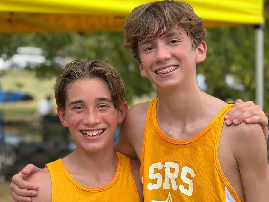 Two students on the track & field team smiling at the camera