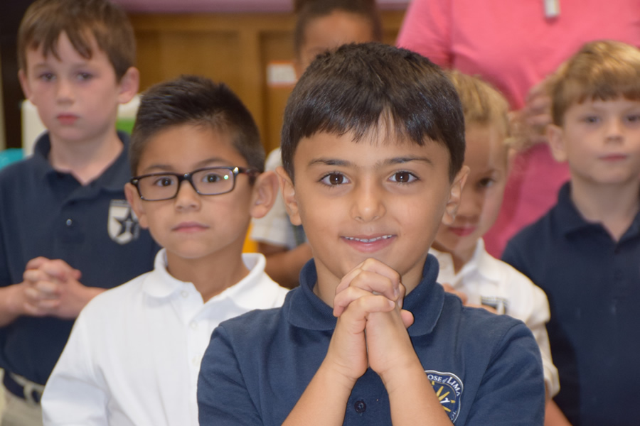 Children praying during weekly mass