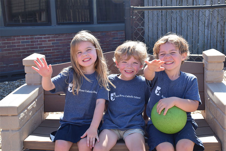 Three kids sit together outside